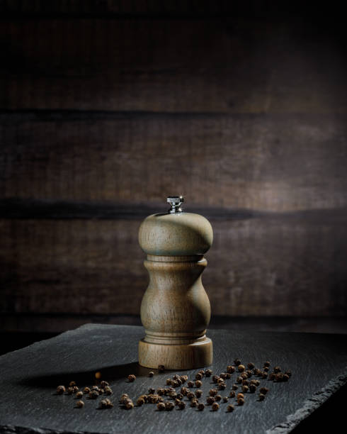 istock pepper mill and peppercorns heap, wooden background, copy space 1391993272