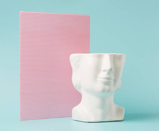 istock Head sculpture against corrugated pink and light blue background. 1391994169