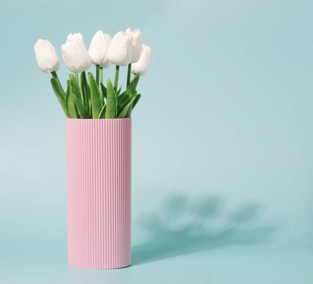 istock Spring flowers in a corrugated pink vase and pastel blue background. 1391994289