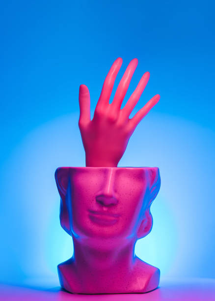 Hand reaching out from statue head and magenta teal led lights. Neon, help surreal concept.