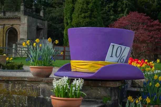 A large mad hatter hat amongst flowers