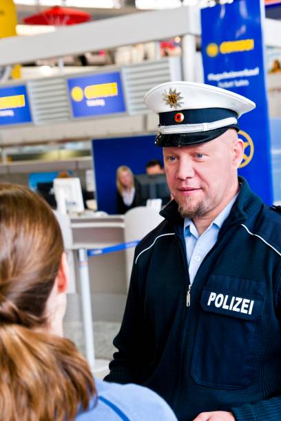 agente di polizia in un aeroporto controlla una giovane donna - ponytail brown hair tourist women foto e immagini stock