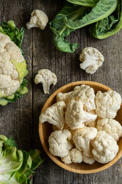 istock Fresh raw organic cauliflower with leaves on rustic background, uncooked vegetable 1391998759