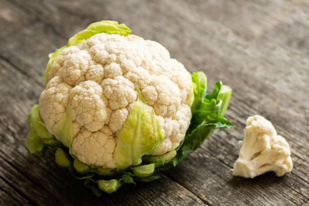 istock Fresh raw organic cauliflower with leaves on rustic background, uncooked vegetable 1391998780