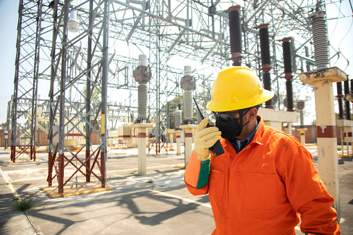 electrical workers in substation, calling by radio