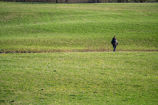 Woman enjoying walking on Intermittent lake Planinsko polje, which is dry, what is one of the characteristics of the karst field - Lake. All those meadows are under the water in rainy season, Slovenia.