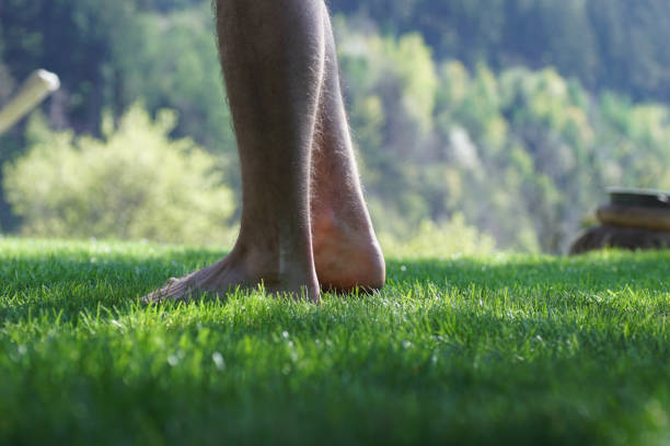 istock Man standing barefoot in the grass. 1391999952