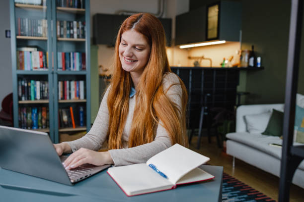 istock Cheerful young woman working on the laptop 1392001220