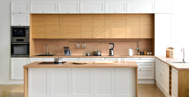 istock Modern new light interior of kitchen with white furniture and table 1392004047