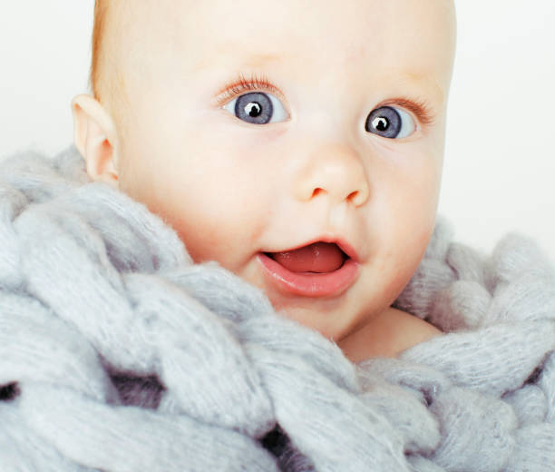 little cute red head baby in scarf all over him close up isolated stock photo