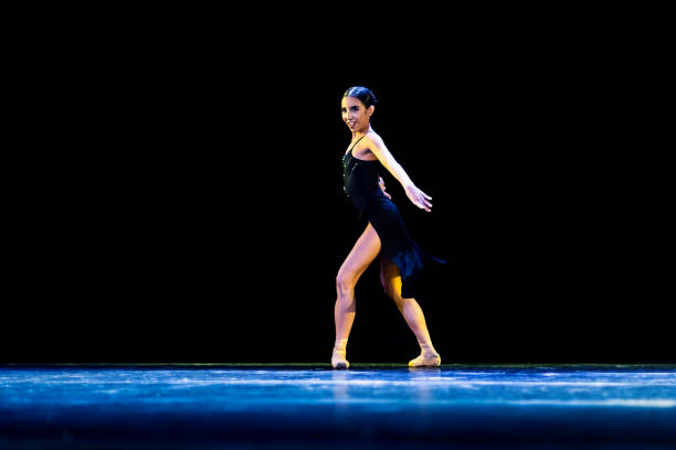 jeune fille interprétant un ballet néo-classique vêtue d’une robe noire sur une scène sombre - round toe shoes photos et images de collection