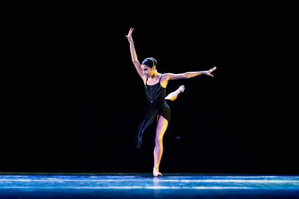 jeune fille jouant un ballet néo-classique vêtue d’une robe noire sur une scène sombre - round toe shoes photos et images de collection