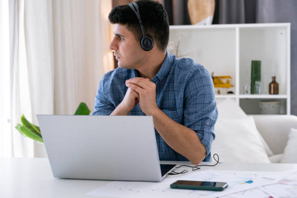 istock Handsome young man working online with laptop at home 1392008947