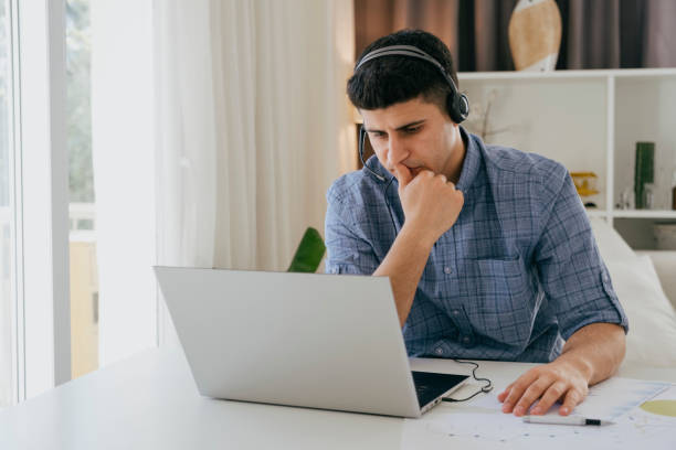 istock Handsome young man working online with laptop at home 1392008954