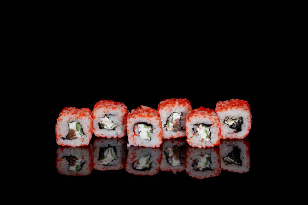 istock Philadelphia roll with salmon, cheese and cucumber on a black background with reflection. Sushi Philadelphia 1392010944