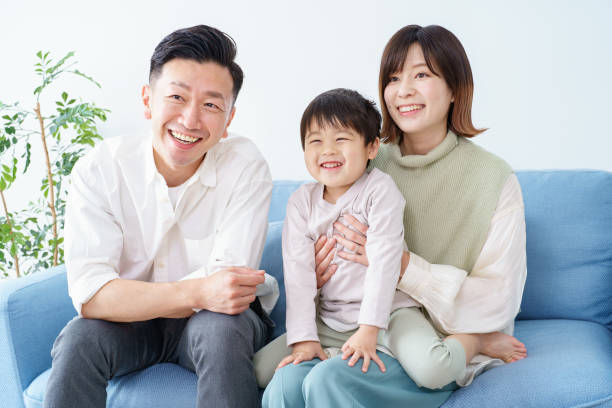 ソファでくつろげる家族 - three person family ストックフォトと画像