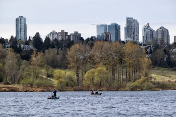 April 16, 2022 Fishing  on the Deer Lake on a sunny day with Burnaby cityscape in the background, BC,  Canada