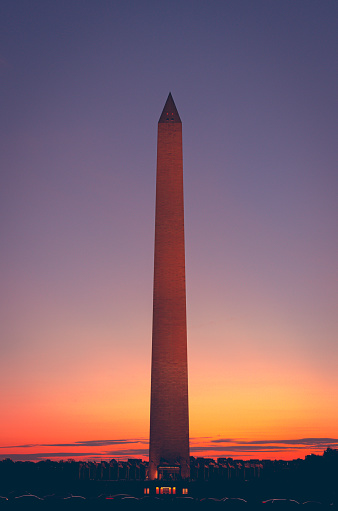The Washington Monument is an obelisk within the National Mall in Washington, D.C. at sunset.
