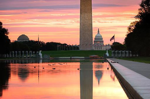 View of Washington Monument and United States Capitol fromLincoln Memorial Reflecting Pool at sunrise in Washington DC, USA.