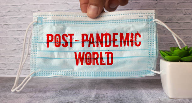 Post-pandemic world symbol. Hand in blue glove with white card. Concept words 'Post-pandemic world'. stock photo