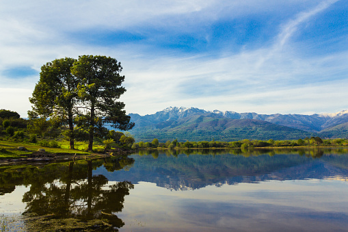 Almanzor peak, in the Gredos mountain, reflected in the water of a lake on a sunny day. Copy space. Selective focus.