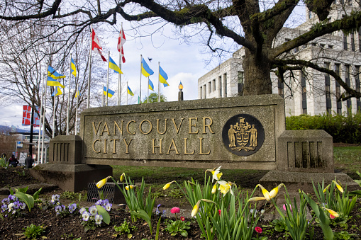 April 9, 2022 Vancouver City Hall in springtime with Canadian Flags and Ukrainian Flags, Vancouver, Canada
