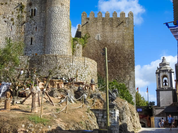 Tourists walk through the narrow streets in the historic town center of Óbidos, Extremadura, Portugal.