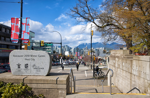April 9, 2022  Vancouver 2010 Winter Games Host City monument near Vancouver City Hall at sunny day with view of Cambie street and background of downtown cityscape and mountains, Vancouver, Canada