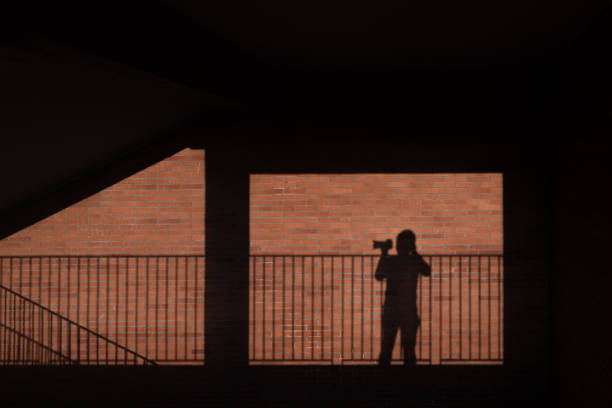 A photographer's shadow on the red brick wall