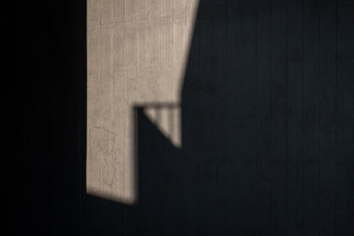 Light and shadow produced by sunlight refraction on the concrete wall