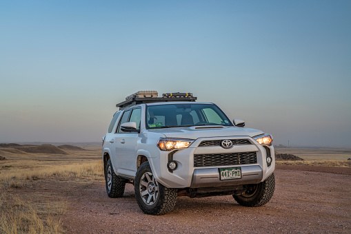 Fort Collins, CO, USA - April 16, 2022: Toyota 4Runner SUV at dusk parked at a trailhead in Soapstone Prairie Natural Area in Colorado foothills.