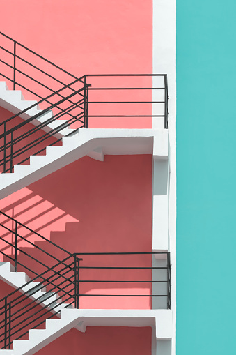 istock Sunlight on surface of fire escape outside of colorful pastel building in vertical frame 1392037331