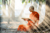 istock Buddhist monk in buddhism school monastery reading Buddhist lessen book 1392044273