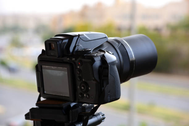 istock A digital camera fixed on a tripod for time lapse footage and video recording with a blurred top view of a city street and buildings 1392045712
