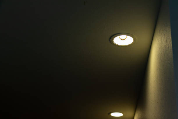 Ceiling downlights that illuminate the wall of the aisle