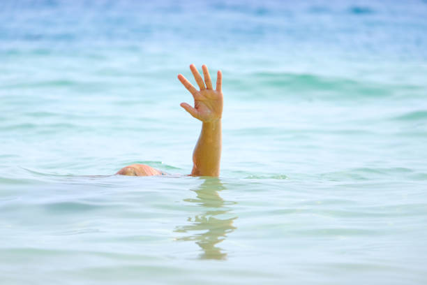 la mano de la mujer se ahogó, él levantó la mano y pidió ayuda por ahogarse en el mar. - arms lifted fotografías e imágenes de stock