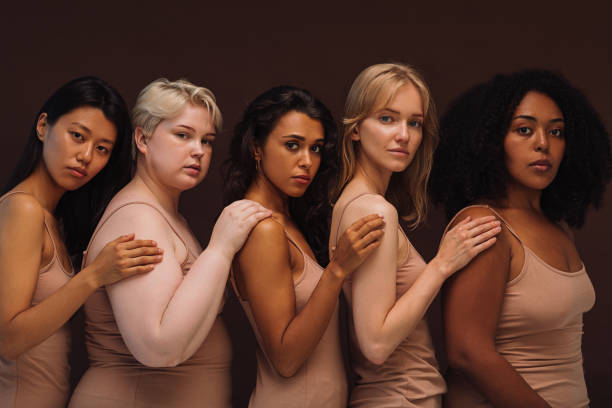 Group portrait of a young diverse women. Five females of different body types and races looking at camera in studio. stock photo