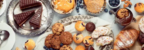 Photo of Dessert table with all kinds snacks on light background.