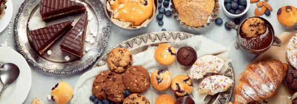 десертный стол со всевозможными закусками на светлом фоне. - biscuit cookie cake variation стоковые фото и изображения