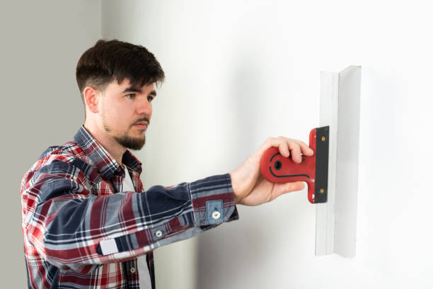 istock repairman builder puttying a white wall with a construction spatula 1392059779