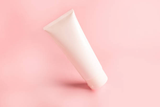 istock clean white plastic tube with body cream on pink background 1392059932