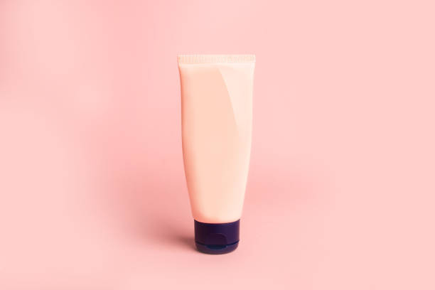 istock clean beige plastic tube with face cream on pink background 1392060871