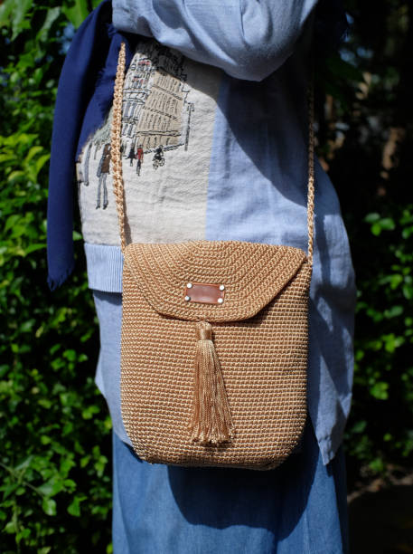 A brown kniting sling bag worn by a woman