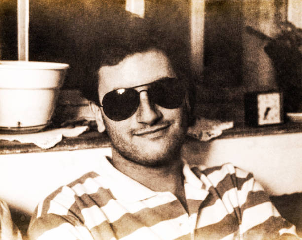 Black and white grainy portrait of young man with sunglasses stock photo