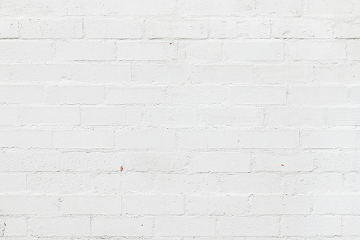 Empty background of wide cream brick wall texture. Beige old brown brick wall concrete or stone textured, wallpaper limestone abstract flooring. Grid uneven interior rock. Home decor design backdrop.