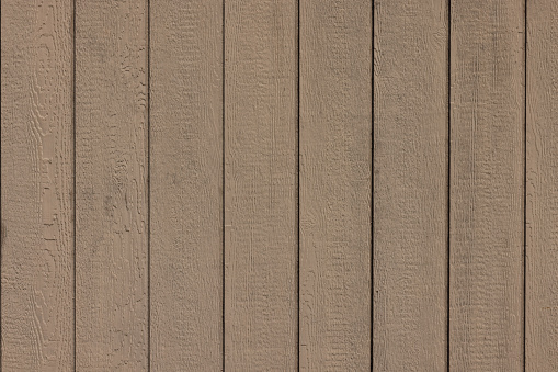 Wooden fence painted in a beige color with evidence of a repair.