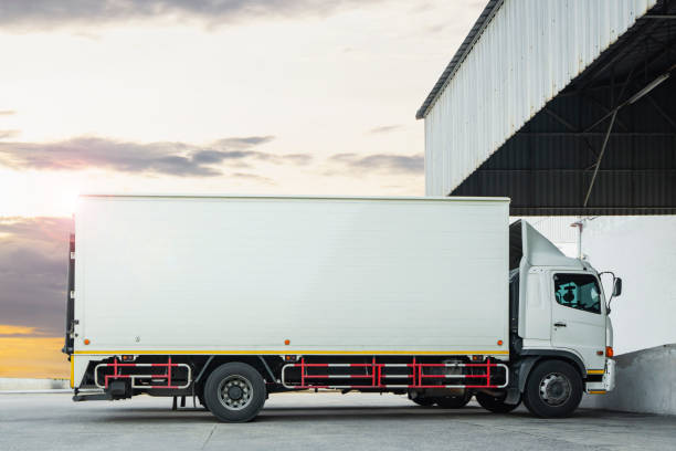 istock Cargo Trucks Parked at Warehouse with Sunset Sky. Shipping Container Trucks Freight Distribution. Lorry. Truck Transport Logistics. 1392069492