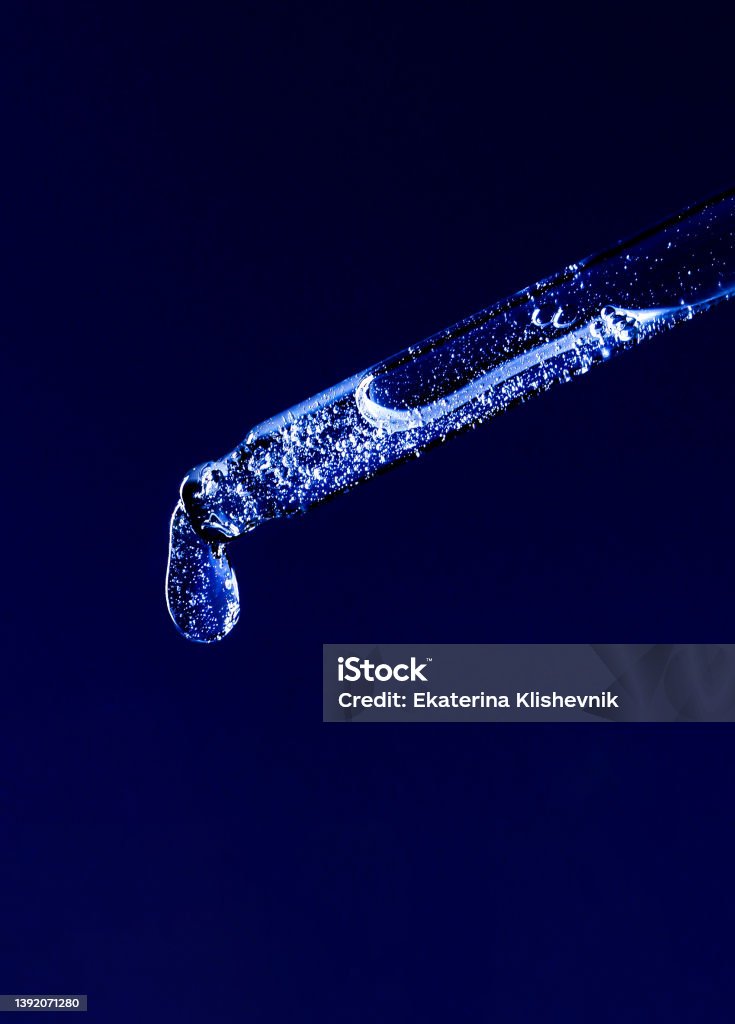 serum pipette with a falling drop on a dark background Color Image Stock Photo