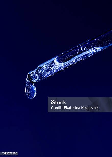 Serum Pipette With A Falling Drop On A Dark Background Stock Photo - Download Image Now