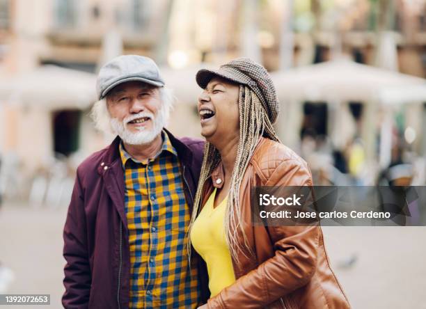 Multiracial Senior Couple Having Fun In The City Retired Travellers Life Focus On Women Stock Photo - Download Image Now